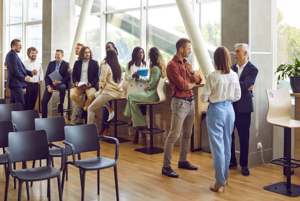 Group of diverse business people chatting after meeting standing in conference room.